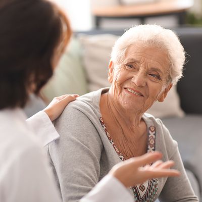 Eine Frau im Gespräch mit einer älteren Frau, beide wirken interessiert und aufmerksam